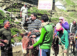 An Army jawan offers water to yatris arriving at Pahalgam from Jammu on Thursday