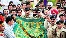 Border Security Force personnel receive a chaddar from Pakistan Rangers during the annual festival at Chamliyal near the India-Pakistan border in Jammu on Thursday