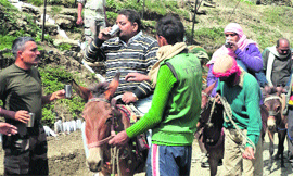 An Army jawan offers water to yatris arriving at Pahalgam from Jammu on Thursday.