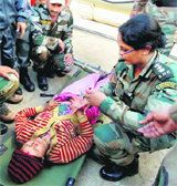An Army doctor examines a pregnant woman after being rescued in Tajim.