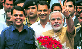 Gujarat Chief Minister Narendra Modi with Maharashtra BJP president Devendra Fadnavis (L) on his arrival at the Mumbai airport on Thursday.