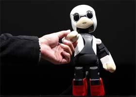 Humanoid communication robot Kirobo shakes hands with Tomotaka Takahashi, CEO of Robo Garage Co and project associate professor, Research Centre for Advanced Science and Technology (RCAST), the University of Tokyo, during its unveiling in Tokyo on Wednesday