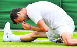 Grigor Dimitrov (top) of Bulgaria slips during his match against Grega Zemlja of Slovenia. 