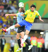 Brazil's Fred (R) fights for the ball with Uruguay's Diego Lugano during the Confederations Cup semifinal at the Estadio Mineirao on Thursday.