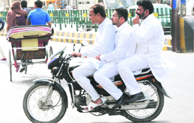 Bharat Bhushan Jindal, former secretary, NGO cell, BJP, drives with two persons riding pillion near the Hanuman Chowk in Bathinda on Friday.