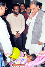 Chief Minister Vijay Bahuguna enquires after the health of a two-year-old girl who was found abandoned at Gaurikund after the rain fury at Doon Hospital on Friday.