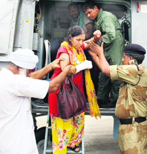 An injured pilgrim is helped to get down from a chopper at Gauchar on Friday.