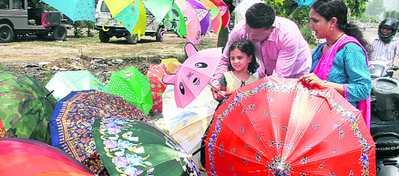A young girl selects an umbrella along with her parents for the rainy season in Jalandhar on Friday.