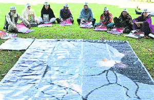 Relatives of disappeared Kashmiri youths with photographs of their missing family members as they hold a sit-in at Srinagar on Friday.  