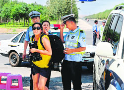 The police detains a journalist on the road to riot-affected Lukqun in Xinjiang province on Friday.  AFP