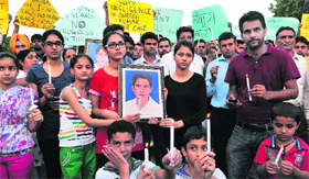 Family members of Suresh Kumar along with city residents during a candlelit protest at Sector 17 Plaza in Chandigarh on Saturday.