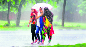 Girls save themselves from rain near Sukhna Lake on Saturday.