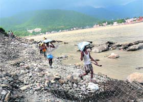 Damage control: Workers engaged in repairing damaged embankments along the Ganga in Rishikesh on Saturday