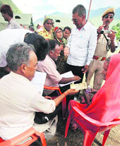 Uttarakhand officials giving financial help to pilgrims at Gauchar. 