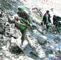 An armyman carries an elderly woman up a hillside during the Uttarakhand rescue. 