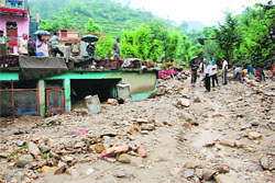 Debris accumulated amidst houses at Paithani town in Pauri Garhwal.