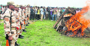 ITBP men observe silence during the crematon of their colleague Inspector Bhim Singh at Bobiyan village in Kathua on Saturday. 