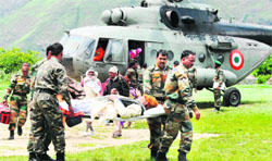 Army men carry a pilgrim rescued from Badrinath by an IAF helicopter at Joshimath on Saturday.  AFP
