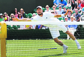 Victor Troicki drops racquet as he lunges for the ball at the net against Mikhael Youzhny on Saturday. 