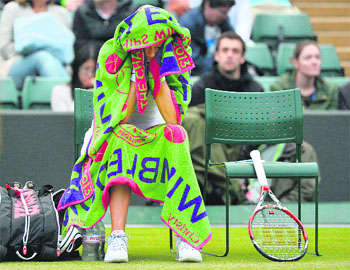 Petra Kvitova sits covered in towels after losing the second set during the match against Ekaterina Makarova of Russia. 