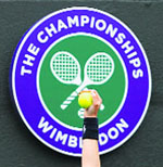 A ball girl holds tennis balls in front of the All England Lawn Tennis and Croquet Club logo. 
