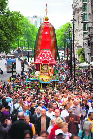 A huge number of devotees walk alongside chariots duringthe yatra through central London