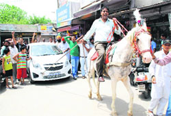 Former municipal councillor Vijay Kumar uses a horse to pull a car while holding a demonstration against the recent hike in the price of petrol, at Parasram Nagar in Bathinda on Sunday. 