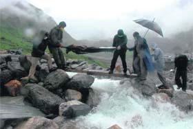 Policemen carry a body for cremation in the flood-hit Kedarnath area on Sunday