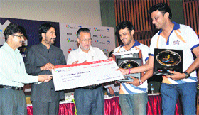 Tourism Minister Ghulam Ahmad Mir gives a cheque to a winner in Srinagar on Sunday.