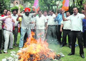 Up in arms: BJP activists burn an effigy of Partap Singh Bajwa, president of  the Punjab state Congress, during a protest in Amritsar on Monday.  tribune photo
