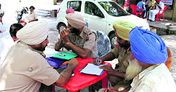 The policemen record the statement of a resident of Naruana village, outside the Civil Hospital in Bathinda on Monday