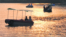 Visitors enjoy boating during an evening at Karan Lake in Karnal. 