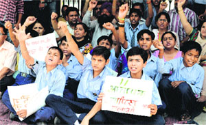 Teachers and students stage protest at SAN Senior Secondary School in Ludhiana on Monday. 