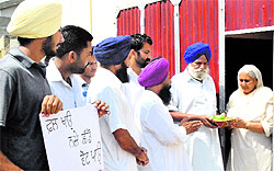 Supporters of a panchayat poll candidate distribute mangoes allegedly to lure voters at a village near Patiala on Monday
