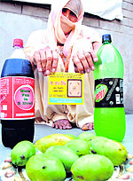 A woman shows mangoes and bottles of soft drinks given by a political candidate during canvassing in Patiala on Monday