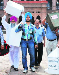Staff on the panchayat election duty carry ballot boxes at Khalsa College in Amritsar on Tuesday.