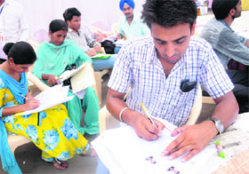 Aspiring candidates fill admission forms at a help desk at Panjab University in Chandigarh on Tuesday.