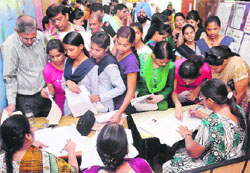 Students, along with their parents, deposit fees for admission to Class XI at Government Model Senior Secondary School in Sector 20, Chandigarh, on Tuesday.