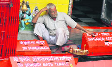 A priest waits for pilgrims at Shri Sringeri Math, Har-ki-Pauri, in Haridwar on Tuesday. 