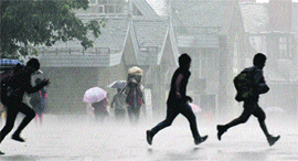 People run for shelter during a heavy rain in Shimla on Tuesday.