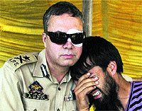 Inspector General of Police Abdul Gani Mir consoles the brother of policeman Mushtaq Ahmad, who was killed during an encounter with militants in Pulwama on Monday