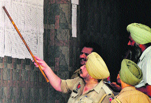 A policeman looks at the duty chart displayed on a wall ahead of the panchayat poll in Ludhiana on Tuesday. 