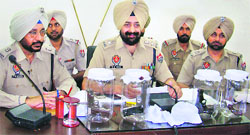Sangrur SSP Mandip Singh Sidhu (left) shows the seized pistols in Sangrur on Tuesday. A Tribune photograph
