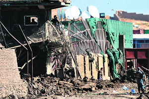 Security men stand at the entrance of a logistics company in Kabul on Tuesday after a suicide attack. 