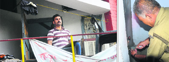 Vineet Jakhar, a student of PU, sits in the balcony. He was locked in his room at the Boys' Hostel Number 1 at Panjab University in Chandigarh; and (right) a policeman opens the lock of the room on Wednesday.