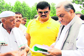 Chief Minister Vijay Bahuguna and local legislator Kunwar Pranav Singh Champion listen to the woes of flood-hit people in the Khanpur area, Roorkee, on Wednesday