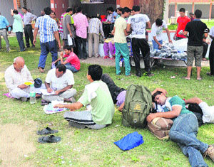 Yatris take a nap near a registration counter for Amarnath Yatra in Jammu on Wednesday.