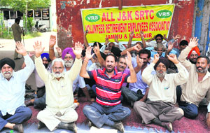 Retired employees of the State Road Transport Corporation protest outside the exhibition ground in Jammu on Wednesday. 
