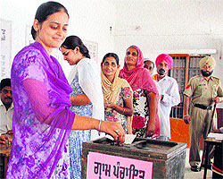 A female voter casts her vote for the panchayat election at Parsrampur village near Jalandhar on Wednesday