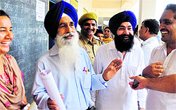 Rival candidates Jaspal Singh (in blue shirt) and Jarnail Singh (in white kurta) share a light moment at Threeke village